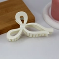 Close-up of cream white bow hair claw clip with glossy finish and strong grip teeth - Glossy White