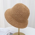 Dettaglio dei motivi a uncinetto traforati su un cappello a secchiello in paglia estivo - Cachi