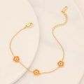 Close-up of golden stainless steel bracelet with sweet orange flower charms and lobster clasp - Orange