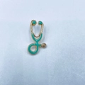 Creative stethoscope brooch with mint green enamel inlay and polished gold finish - Blue Green with Gold Base