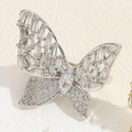 Makroaufnahme von Silber-Schmetterlingsring mit funkelnden Zirkonia auf weißem Sockel - Einstellbar Offen / Silber asymmetrischer Schmetterling