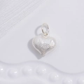Detailed close-up of a silver heart pendant with fine textured scrollwork relief - Silver Threaded Swirl Heart Pendant