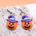 Gros plan de boucles d'oreilles citrouille d'Halloween en résine avec un chapeau - Citrouille avec chapeau de sorcière