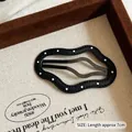 Polka dot black leather wave hair clip accessory shown in a wooden jewelry box - Black Cloud White Polka Dot