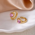 Detailed close-up of golden heart earrings with pink crystal on white ceramic plate - Heart Zirconia / Pink