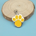 Detail view of a yellow paw print charm with metal lobster clasp on a wooden base - 32*25*2mm / Yellow