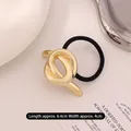 Minimalist gold knot metal hair tie with black elastic band on white background - Knotted Kc Gold