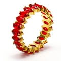 Close-up of eternity ring featuring marquise-cut red stones in a gold plated setting - Gold + Red Zirconia