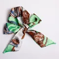 Green twilly silk scarf with equestrian horse pattern tied in a bow style - S18-Grass Green Harness Style