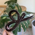 Detail showing a large dark brown resin hair claw clip with a strong gold metal spring - Chocolate