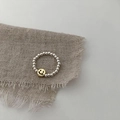 Minimalist silver beaded ring with a golden smiley face charm on a rustic fabric background - Gold Smiley Beaded Ring (J2695)