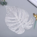 Detalle del mantel individual plateado con forma de hoja de monstera y diseño calado - 38cm / Plateado