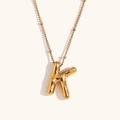 Macro detail of 18K gold plated balloon letter K pendant on a satellite bead chain - Gold-K