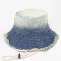 Detail of gradient wash denim bucket hat featuring frayed edges and adjustable drawstring - Dark Blue