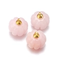 Detail of pink pumpkin-shaped stone pendants with golden metal loops on white background - Pink