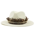 Detail of straw boater hat featuring brown feathers and gold skull metal accents - Creamy White