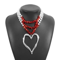 Detail of layered bohemian necklace with faux pearls, red stones, and large silver heart - Heart Pendant / Red + Silver