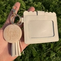 Close-up of cream PU leather card holder with tassel and engraved I Love You charm - Off-white