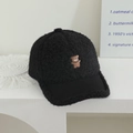 Close-up of black teddy fleece baseball cap with cute brown bear embroidery detail - Hug Bear / Black