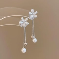 Dettaglio di orecchini a fiore con perle lunghe nappe argentate e dettagli in strass lucidi - Argento