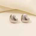 Macro shot of silver heart stud earrings made of 304 stainless steel on a beige texture - Pointed Heart (D152-S)