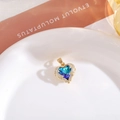 Detailopname van de hartvormige hanger met blauw-groene kristal en zirkonia-omlijsting - Alleen hanger / Gouden Basis Blauw