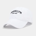 Détail de la broderie Brooklyn sur une casquette en coton lavé blanc avec œillets d'aération - Réglable / Blanc