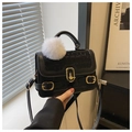 Dettaglio borsa nera trama coccodrillo con chiusura in metallo dorato e ciondolo pompon - Con ciondolo a palla di pelo bianca / Nero
