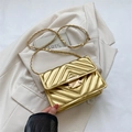 Borsa a tracolla dorata con trapuntatura a V e catena su un blazer bianco elegante - Oro