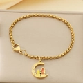 Détail d'un bracelet doré avec pendentif lune, figurines gravées et petits diamants - Style Lune Figure Strass (KB203649-Z)