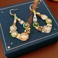 Nahaufnahme von Vintage-Quastenohrringen mit Perlen und Strass auf einer blauen Box - Zirkon Hohle Pfauenfeder Ohrhaken (25#)