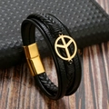 Dettaglio macro del bracciale in pelle intrecciata nera con ciondolo pace dorato - Nero/Oro