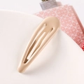 Close-up of a 5cm teardrop-shaped candy color metal BB hair clip on a ceramic tray - Off White