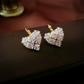Macro shot of gold heart hoop earrings with shimmering cubic zirconia on leather - Gold Zircon Heart Ear Buckle