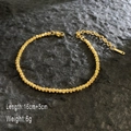 Detailed view of 18K gold plated sparkling bead chain with lobster clasp on rock background - Sparkling Solid Chain / Gold