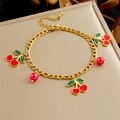 Golden bracelet with vibrant red cherry charms and green leaves on a jewelry display - Red Cherry Enamel Bracelet (B1512)