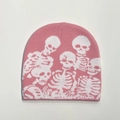 Macro detail of pink knitted beanie featuring white skull patterns and soft ribbed texture - One Size / Pink