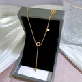 Detailed view of a gold titanium steel necklace with ring and V-shape pendant in a jewelry box - Gold (K234)