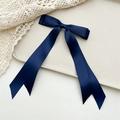 Detailed view of long navy blue satin ribbon bow hair clip with elegant glossy texture - Navy Blue