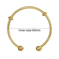 Detail view of a 60mm inner diameter golden knot open bangle bracelet with ball ends - Open Ball End Bangle (Q0561) / Gold