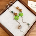 Dettaglio di lunghi orecchini boho con dischi verdi e perle dalle tonalità della terra - Gancio per orecchie Verde Caffè