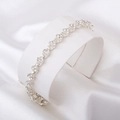Détail d'un bracelet cœur argenté avec cristaux sur support de bijoux et soie blanche - Bracelet cœur romain / Argent