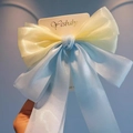 Detail of the oversized organza bow clip in yellow and pearlescent blue finish - Yellow Blue