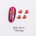 Macro detail of 3D red heart nail gems with gold base on long burgundy nails - Gold Heart Red Rhinestone Style(8714)