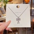 Silver bow pendant necklace in 18K titanium steel with zircon inlay on white display card - X458 Silver Bow Zirconia Pendant