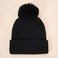 Close-up of black ribbed knit beanie featuring a large pom-pom and folded cuff detail - One Size / Black