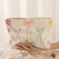 Beige corduroy makeup bag with colorful bow prints and a gold zipper closure - Beige Colorful Bow (FP223746)