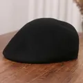 Classic black wool newsboy cap for women with vintage flat brim on a wooden surface - M (56-58cm) / Black
