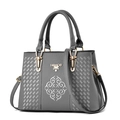 Primer plano del bordado floral plateado y herrajes dorados en el bolso gris - gris oscuro