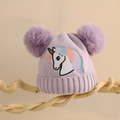 Detail der lila Einhorn-Strickmütze für Mädchen mit zwei flauschigen Bommeln und Stickerei - Einheitsgröße (2-6 Jahre) / Lila